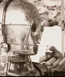 a robot is smoking a cigarette while a person holds a lighter
