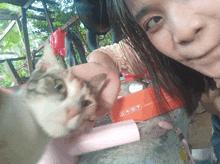 a woman holds a cat in front of an orange box that says fragile