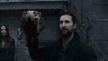 a man with a beard is holding a strange object in his hand