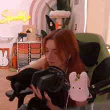 a woman is holding a black cat in front of a sign that says sparkle
