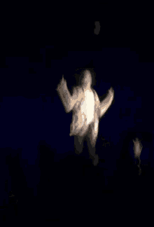 a man is jumping in the air in a dark room