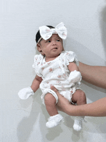 a baby wearing a white headband and gloves