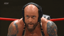 a man in a wrestling ring with a aew logo on the bottom