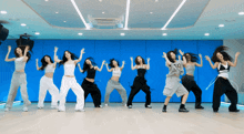 a group of young women are dancing in a room