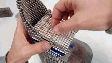 a person is holding a stack of magnetic balls in their hands