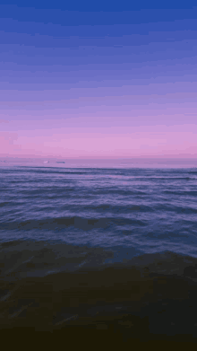 a large body of water with a purple sky behind it