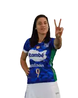 a woman wearing a blue shirt with the number 9 on it giving a peace sign
