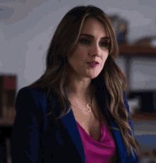 a woman wearing a blue jacket and a necklace with the number 8