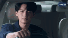 a man is sitting in the driver 's seat of a car and looking at the camera .