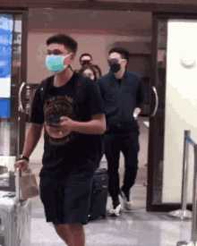 a man wearing a t-shirt that says timberland is walking through an airport