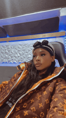 a woman wearing a louis vuitton jacket and a headband