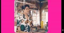 a man in a hawaiian shirt stands next to a sink
