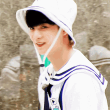 a young boy wearing a white hat and a sailor uniform