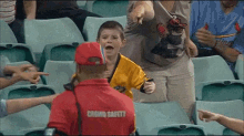 a man in a crowd safety shirt stands in front of a young boy