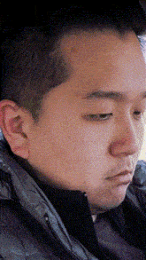 a close up of a man 's face wearing a jacket and tie