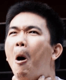 a man with a beard is making a funny face with his mouth open .