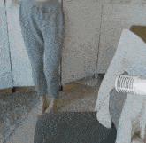 a person in grey sweatpants is standing in front of a white screen