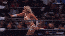 a woman is in a wrestling ring with aew gloves on her hands