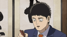a man in a suit and tie is holding chopsticks in his hand