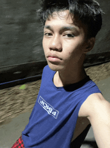 a young man is wearing a blue tank top that says beach