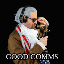 a man wearing a wig and headphones is holding a telephone with the words good comms written below him