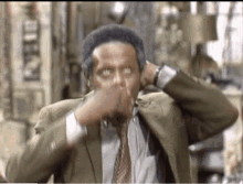 a man in a suit and tie is sitting in a chair with his hands on his head .