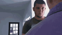 a man in a purple shirt is looking at another man