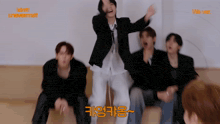 a group of young men are dancing in front of a sign that says we ver.