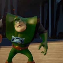 a green cartoon character with a blue x on his chest is standing on stairs