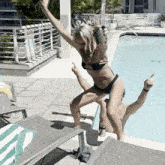 a woman in a bikini is jumping into a swimming pool
