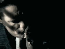 a man in a suit and tie looks at his watch in the dark