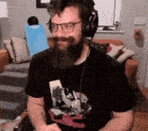 a man with a beard is wearing headphones and a black shirt