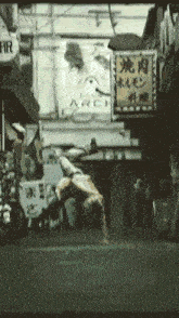 a man is doing a handstand in front of a sign that says ' fir ' on it