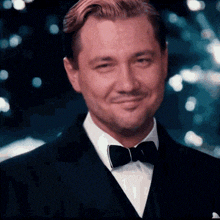 a man in a suit and bow tie is smiling