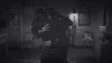 two women hugging each other in a dark room