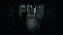 a black and white photo of a dark hallway with a person hanging from the ceiling