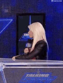 a woman is sitting in front of a microphone on a stage .