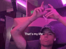 a man holding a wine glass with the words that 's my life written on the bottom