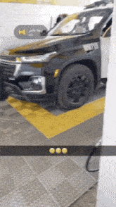 a black car is parked in a parking lot with a yellow line .