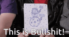 a person holding a piece of paper that says me moon on it