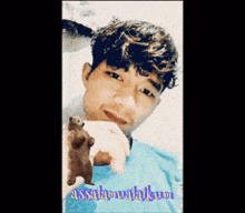 a young man is holding a teddy bear and has the word assalamualaikum on the bottom