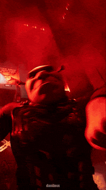 a man in a superhero costume is dancing in a dark room with red lights behind him