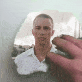 a man in a white shirt is looking through a hole in a mirror