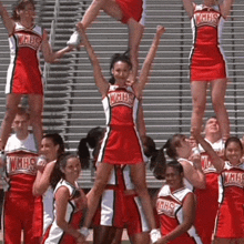 a group of cheerleaders wearing wmhs uniforms perform a cheer routine