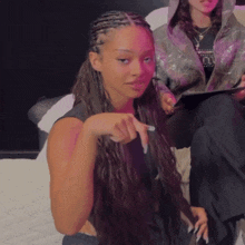 a woman with long nails is sitting on a couch