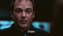 a man in a suit and tie is making a funny face in a dark room .