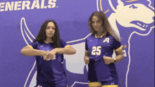 two girls wearing purple uniforms with the number 25 on the front