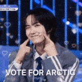 a young man in a suit and tie is making a face with his fingers and the words vote for arctic are above him .