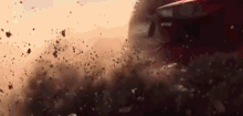 a car is driving down a dirt road and there is a lot of dust coming out of the car .