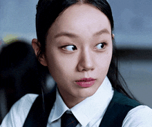 a close up of a woman wearing a white shirt and a tie